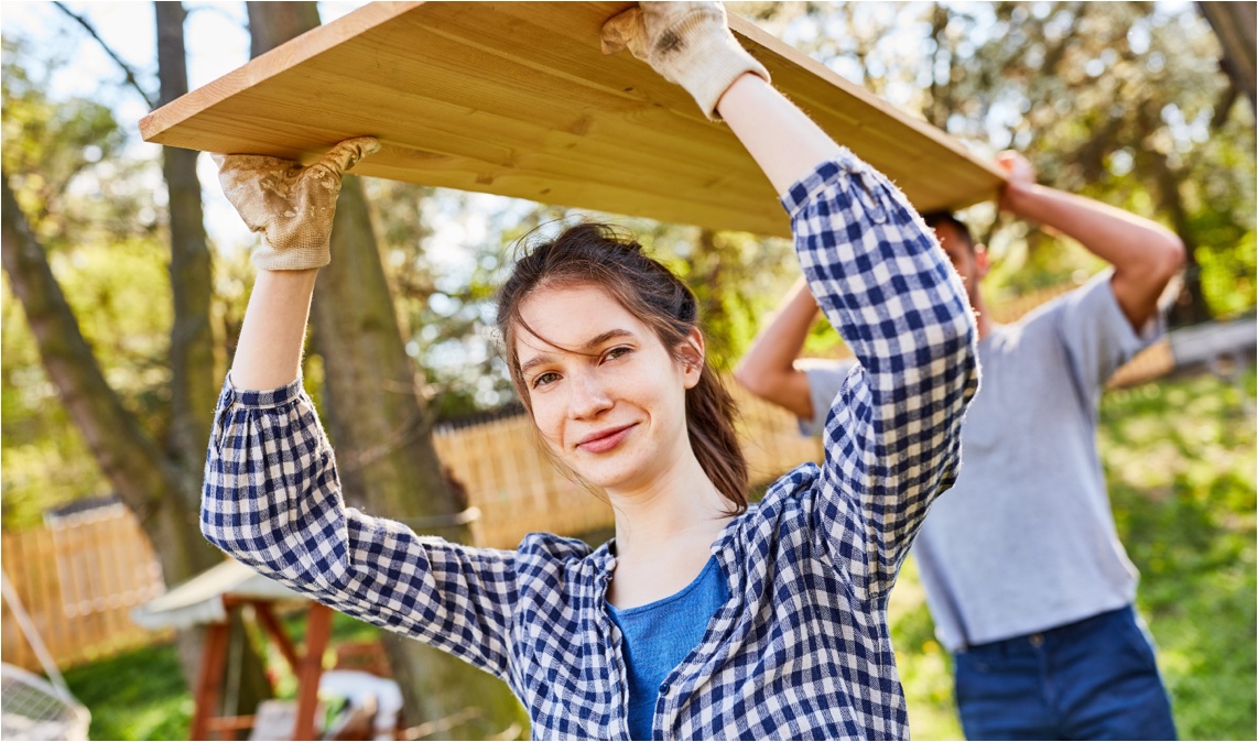 DIY-Inspration für den Garten | Zwei Menschen tragen eine Holzplatte | HolzLand Stoellger in Langenhagen
