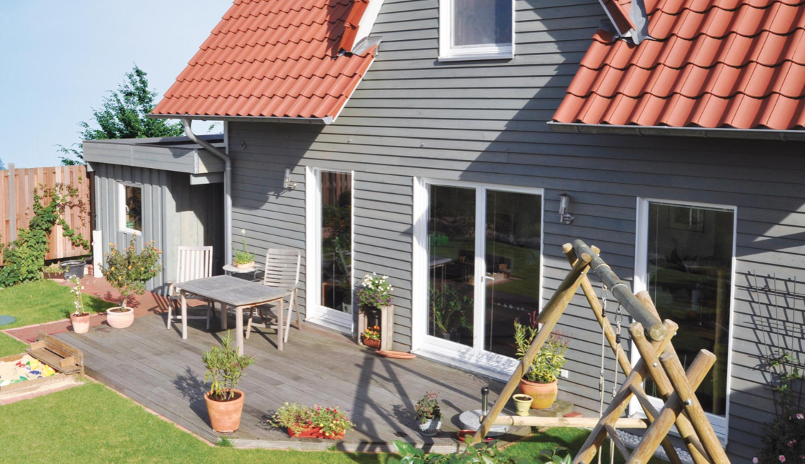 Haus mit grauer Fassade und rotem Dach | HolzLand Stoellger in Langenhagen